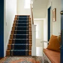 A straight staircase with a carpet runner in a family home